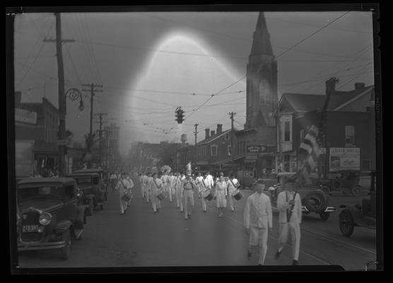 American Legion Parade; band marching down street; partial view of New York Lunch, Adair Drug