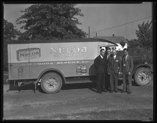 M.D. Food Service; trucks and men (Kraft-Phenix Cheese Company, parked in front of Combs Lumber Company building)