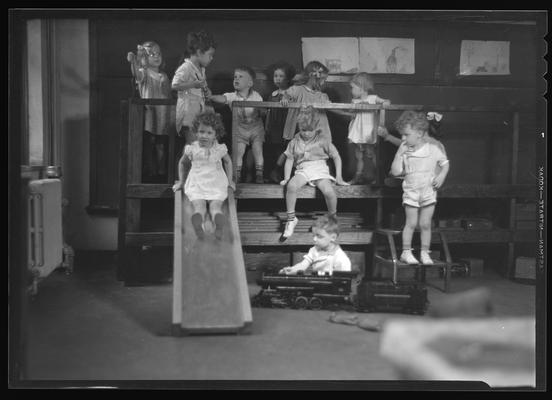 University kindergarten; interior, children playing on slide