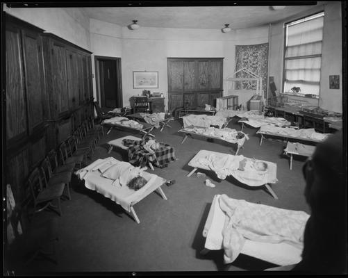 University kindergarten; interior, children napping on cots