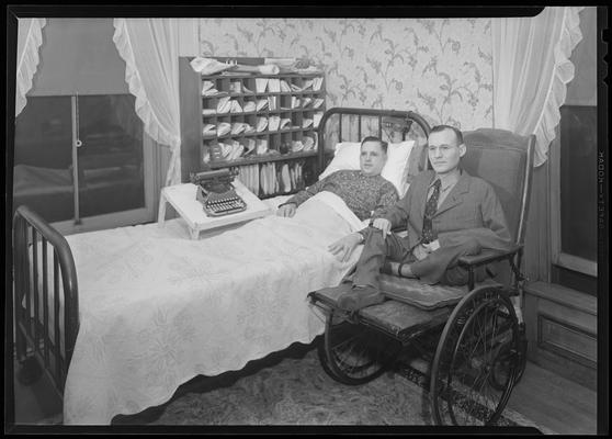 Homer E. Minor; laying in bed with unknown man to his side; typewriter on bed