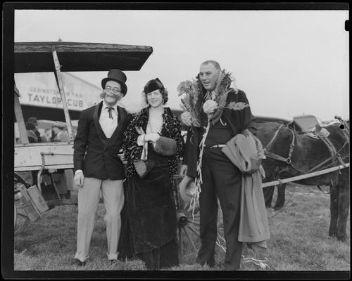 Lexington Airport; group of three unidentified people standing in front of a horse drawn carriage