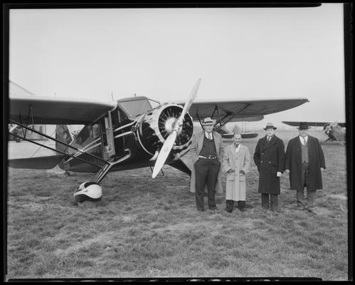 Lexington Airport; three unidentified men standing in front of airplane