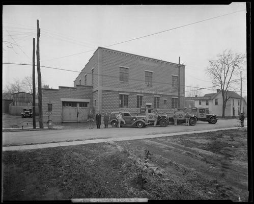 Coca-Cola Bottling trucks in Danville; men standing in front of trucks and building