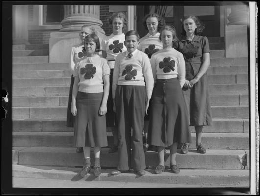 Paris High School ; group of seven students standing on steps of building with shamrocks on shirts