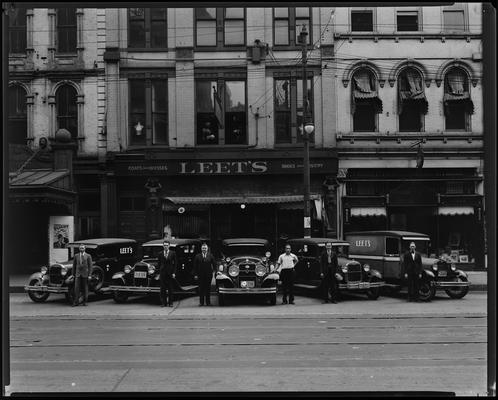 Leet Brothers Furniture Store; exterior, 409-413 West Main Street; men standing with cars outside of building