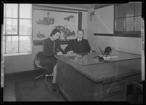 Packard Motor Cars (Vine at Southeastern Avenue) garage; interior of office; man and woman working at desk