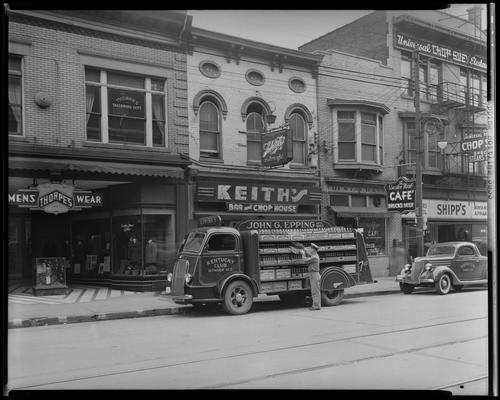 John G. Epping Bottling Works, truck parked in front of Keith's Bar and Chop House (129 East Main), Universal Restaurant (135 1/2 East Main), Shipp's Women's Clothing (135 East Main)