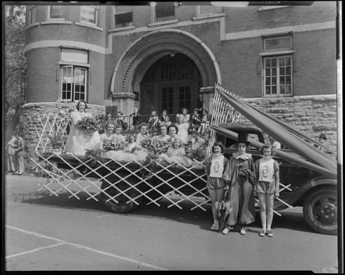 May Queen Activities (1939 Kentuckian) (University of Kentucky), girls riding in the back of a University of Kentucky truck with clown and two girls in costume standing beside