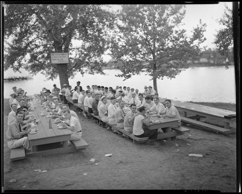 Pure Oil Company picnic; group eating at picnic tables, Lexington Water Company sign