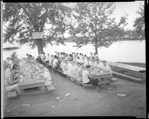 Pure Oil Company picnic; group eating at picnic tables, Lexington Water Company sign