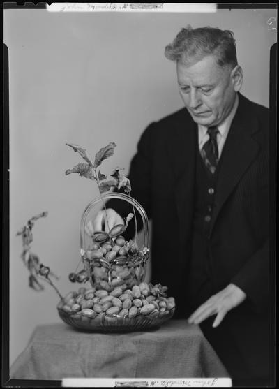 John Mondelli standing next to a bowl of pecans