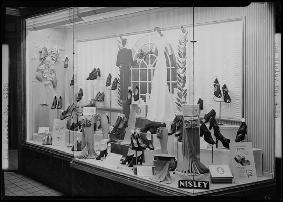 Nisley Company (shoe store), 116 West Main; window display; photographed at night