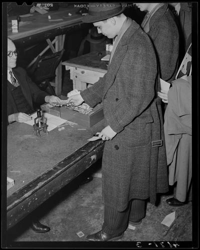 Registration Line; (1939 Kentuckian) (University of Kentucky), man in line handing money to the person behind the registration desk