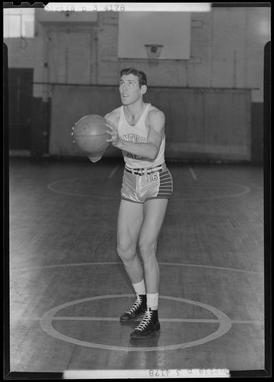 University of Kentucky varsity basketball team; individual team member on basketball court, unidentified number, Curtis poised to throw ball