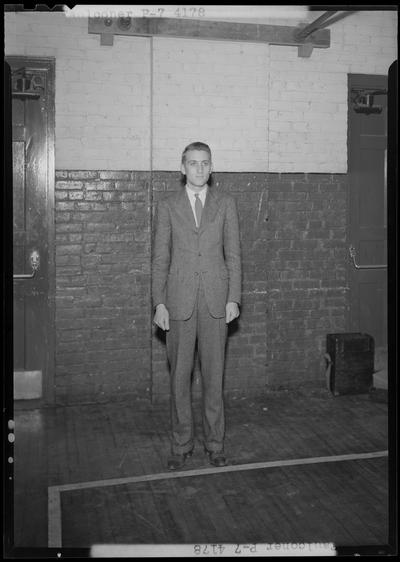 University of Kentucky Varsity basketball team, individual team member? or Coach? (Faulconer) on the basketball court, dressed in a suit