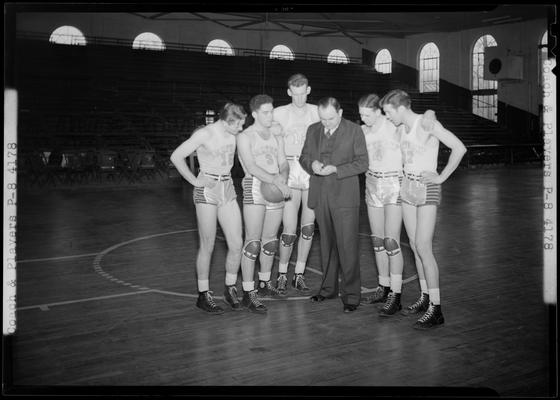 University of Kentucky Varsity basketball team; five players standing around coach