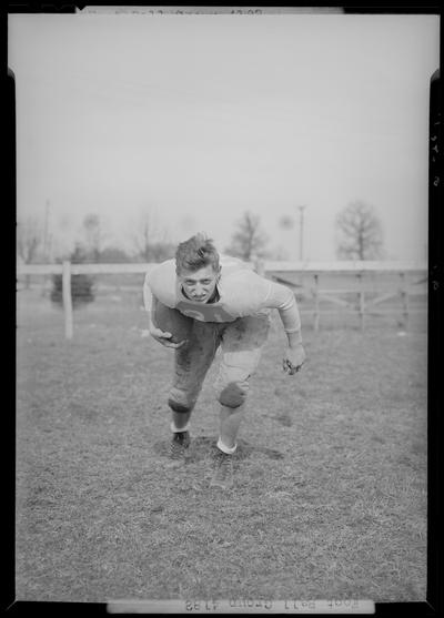 Versailles High School; Football, individual team member portrait, number 31 (no. 31), posing with football under arm on the playing field