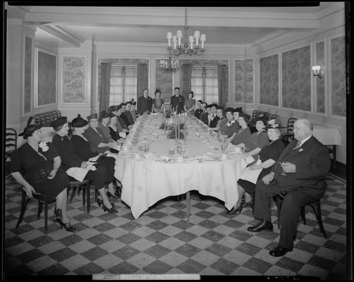 Mr. & Mrs. J.C. Woods & group; sitting at table in dinning room for a banquet