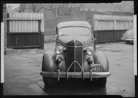 W.W. Williamson; wrecked car parked in front of a garage, damaged driver's side, front view, Kentucky license plate number N415 (no. N415)car