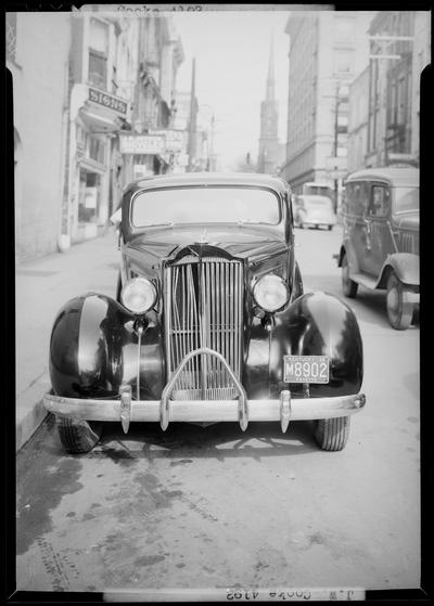 J.W. Cooke; wrecked car parked on the side of the road (North Mill), damaged front grill, view from the front; John B. Joyner Bicycle dealer (109 North Mill) can be seen in the background