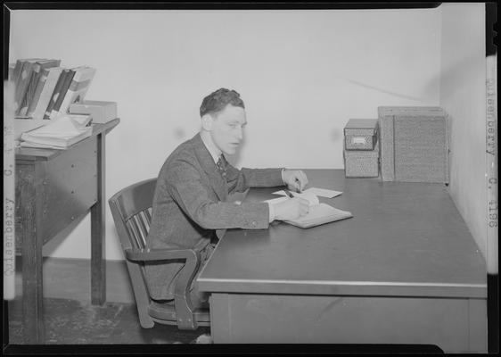 Quisenberry (1939 Kentuckian) (University of Kentucky); man sitting at a desk writing