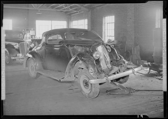 Stoll, Muir, Townsend & Park (attorneys, lawyers; 107 Cheapside); wrecked car parked in a garage, damaged front end, front view