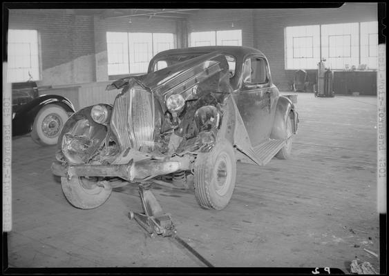 Stoll, Muir, Townsend & Park (attorneys, lawyers; 107 Cheapside); wrecked car parked in a garage, damaged front end, front view