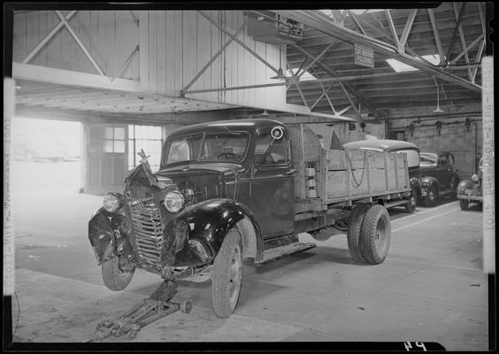 Stoll, Muir, Townsend & Park (attorneys, lawyers; 107 Cheapside); wrecked truck parked in a garage, damaged front end, view from front driver's side corner