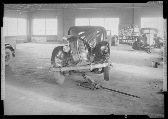 Stoll, Muir, Townsend & Park (attorneys, lawyers; 107 Cheapside); wrecked car parked in a garage, damaged front end, front view