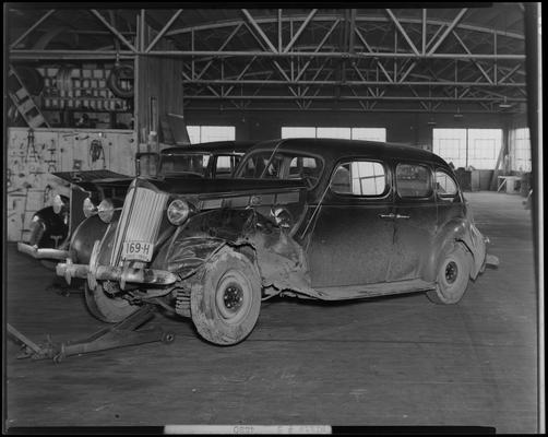 Stoll, Muir, Townsend & Park (attorneys, lawyers); post automobile accident photos requested by Gale Mohney; wreck on Richmond Road between Meyers (attorney George Ross) and Romanoff (attorney McCann); damaged car (vehicle) parked in a garage, view from front driver's side corner; Ohio license plate number 169 H (no. 169H)