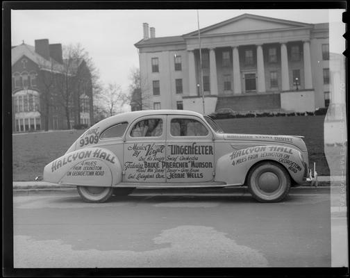 Halcyon Hall; car parked next to curb; advertisements on car read 