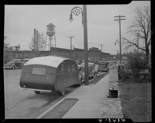 Pershing Rifles, (University of Kentucky); car & trailer parked next to the curb, rear of trailer reads 