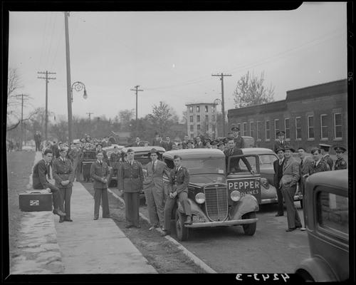 Pershing Rifles, (University of Kentucky); large group of men (some in uniform) standing next to parked cars; 