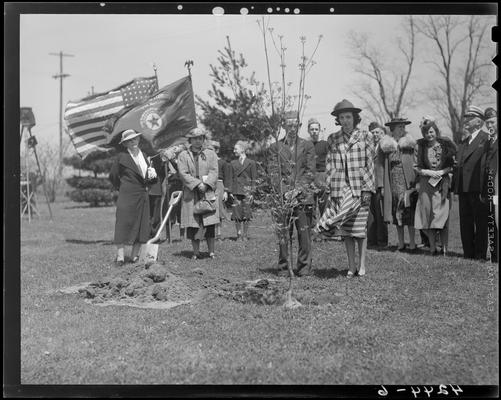 Veterans Hospital; tree planting ceremony, group gathered around a freshly planted tree, American flag and an American Legion Auxiliary flag are being displayed
