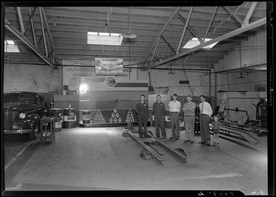 L.R. Cooke Chevrolet (255 East Main); grease rack, service bay; group of men and a child standing in service bay