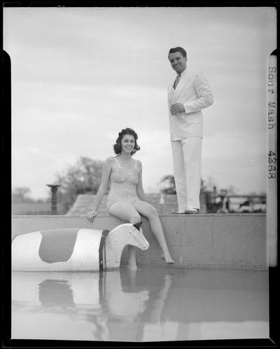 Sour Mash, Kiby Vogt and Joann Young; woman in bathing suit sitting on the edge of a pool; man standing next to the woman drinking out of a bottle