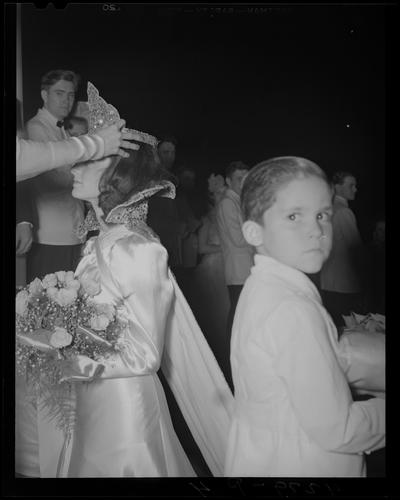 Centre College (Danville); Festival; woman in formal dress holding a bouquet is having a crown placed on her head, a young boy standing next to the woman is looking directly into the camera