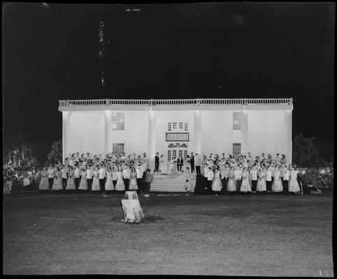 Centre College (Danville); Festival; group portrait; large group of men and women in formal dress (attire) standing in front a large building; night scene