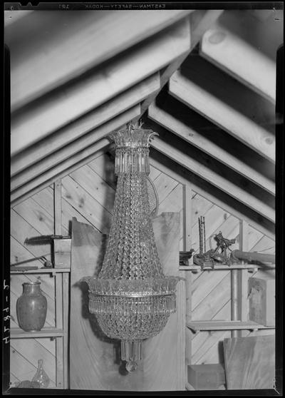 F.W. Witlow; Antique Chandelier hanging from roof rafter, miscellaneous objects on shelving in the background