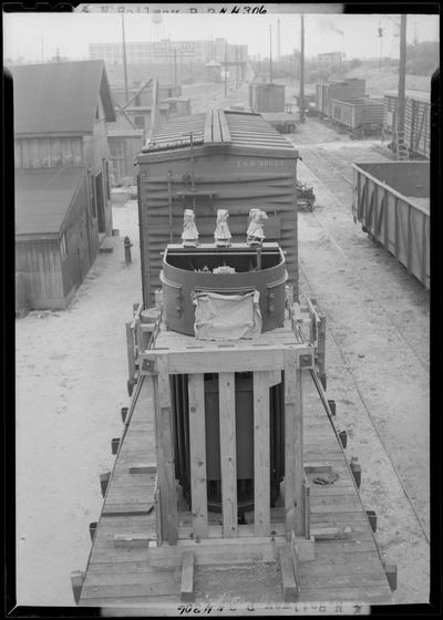 L&N (Louisville & Nashville) Railroad Company; large piece of equipment crated and loaded on the back of a flat bed rail car