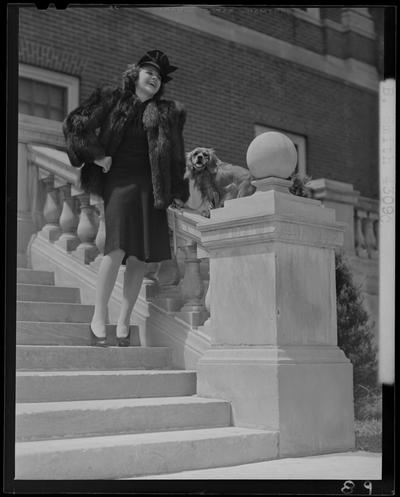 B.B. Smith & Company, 264 West Main; woman in a fur coat standing on the steps to a building while holding a dog by the leash (modeling)