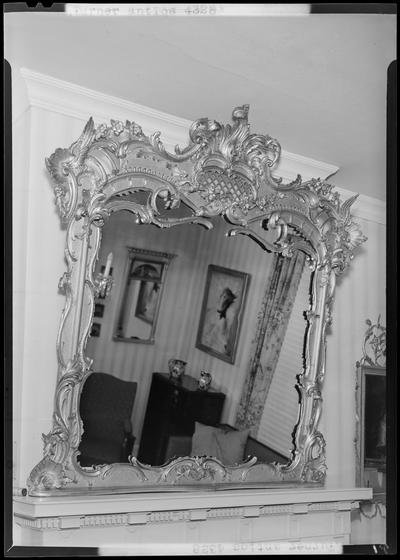 Kathleen Turner; antique mirror hanging above fireplace mantel
