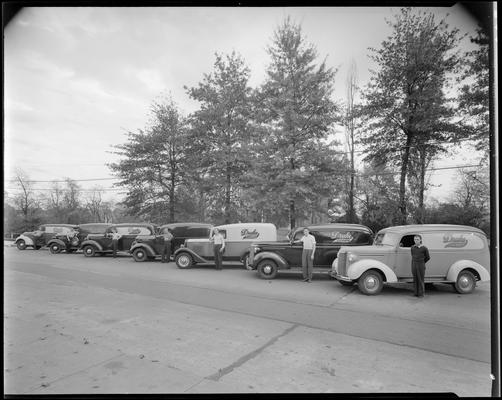 Drake Cleaners & Dyers; seven (7) delivery trucks parked side by side