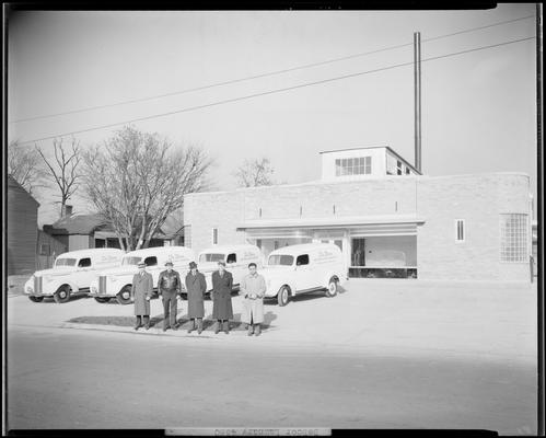 De Boor Laundry and Dry Cleaning, 365 Euclid Avenue: exterior view of business, four delivery trucks parked in front of building, drivers standing in front of trucks