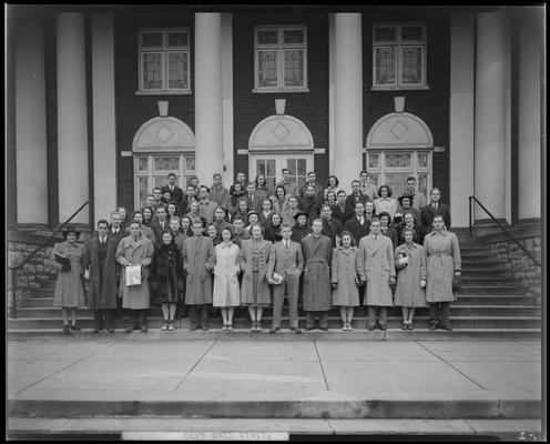 Pitkin Club, (1940 Kentuckian) (University of Kentucky); group portrait in front of a building, one member holding a copy of 