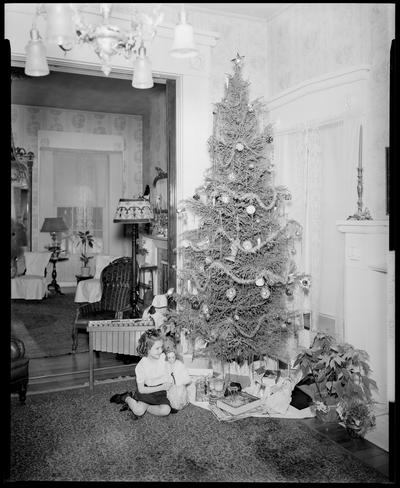 Mrs. W.J. Dineen; interior of home, girl playing with a doll next to a Christmas tree