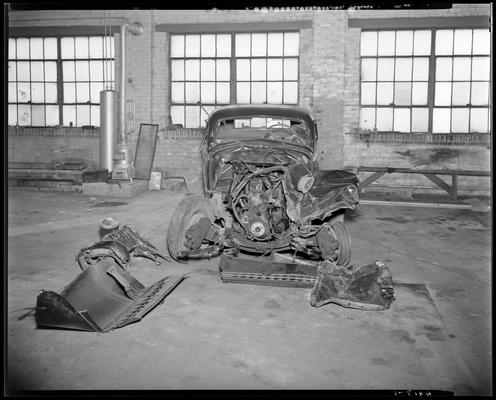 Coca-Cola Bottling Works, 541 West Short; damaged (wrecked) car parked inside garage, front end view