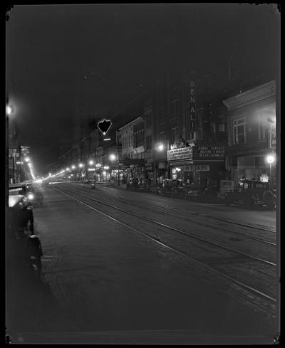 Street scene, north side of 100 block of East Main, night; Ben Ali Theatre (movie theater) visible, marquee advertises 