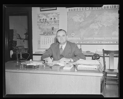 Coach Adolf Rupp seated at desk